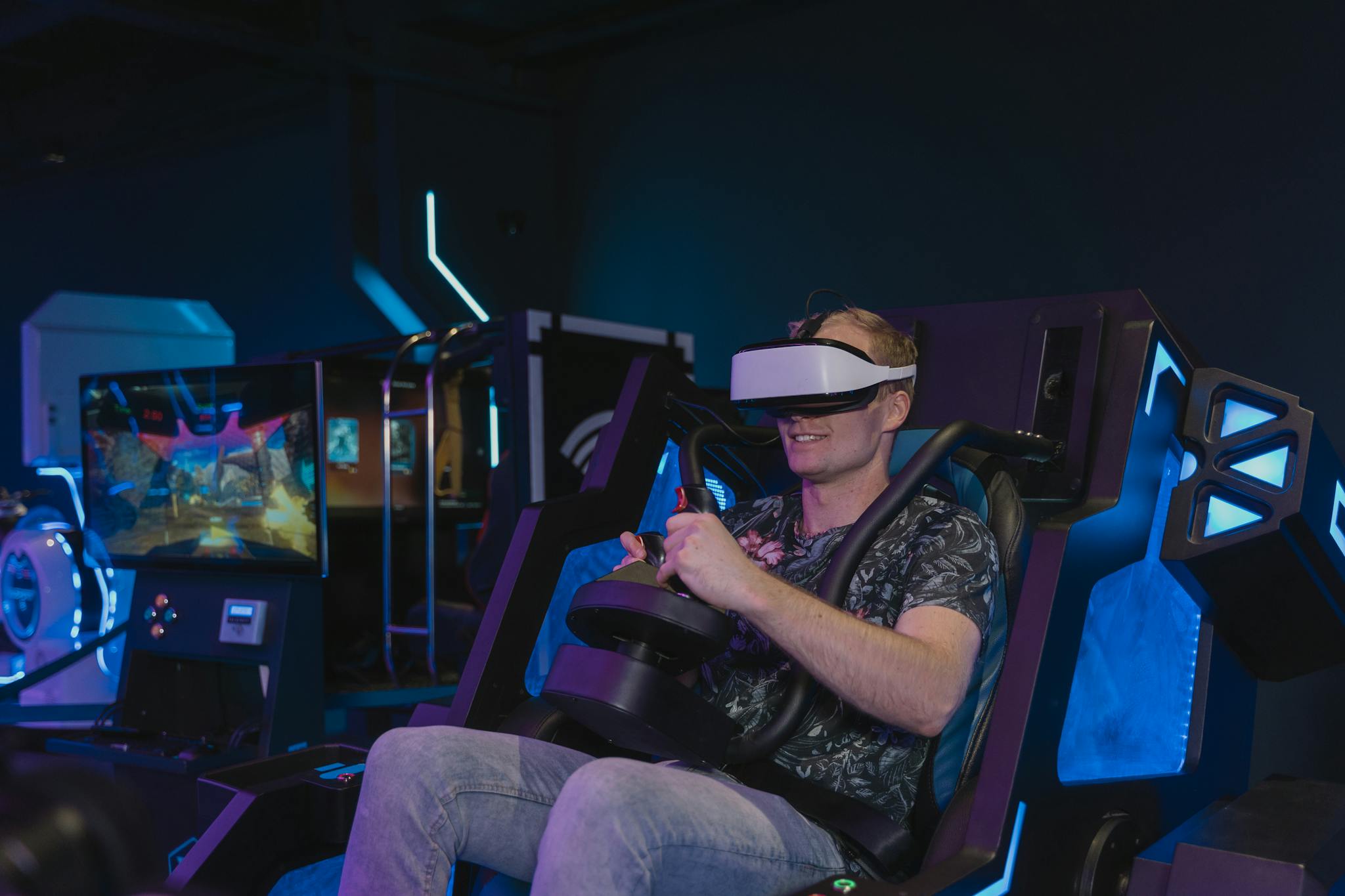 A man enjoying a virtual reality gaming session using a VR headset in a tech setting.
