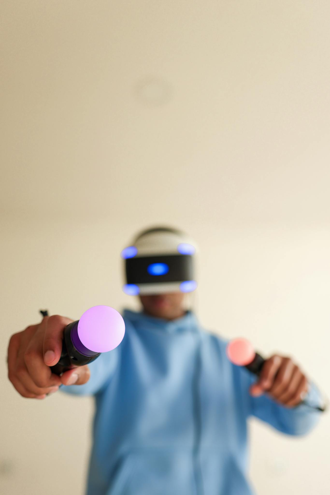 Person enjoying a virtual reality game with VR goggles and interactive controllers indoors.